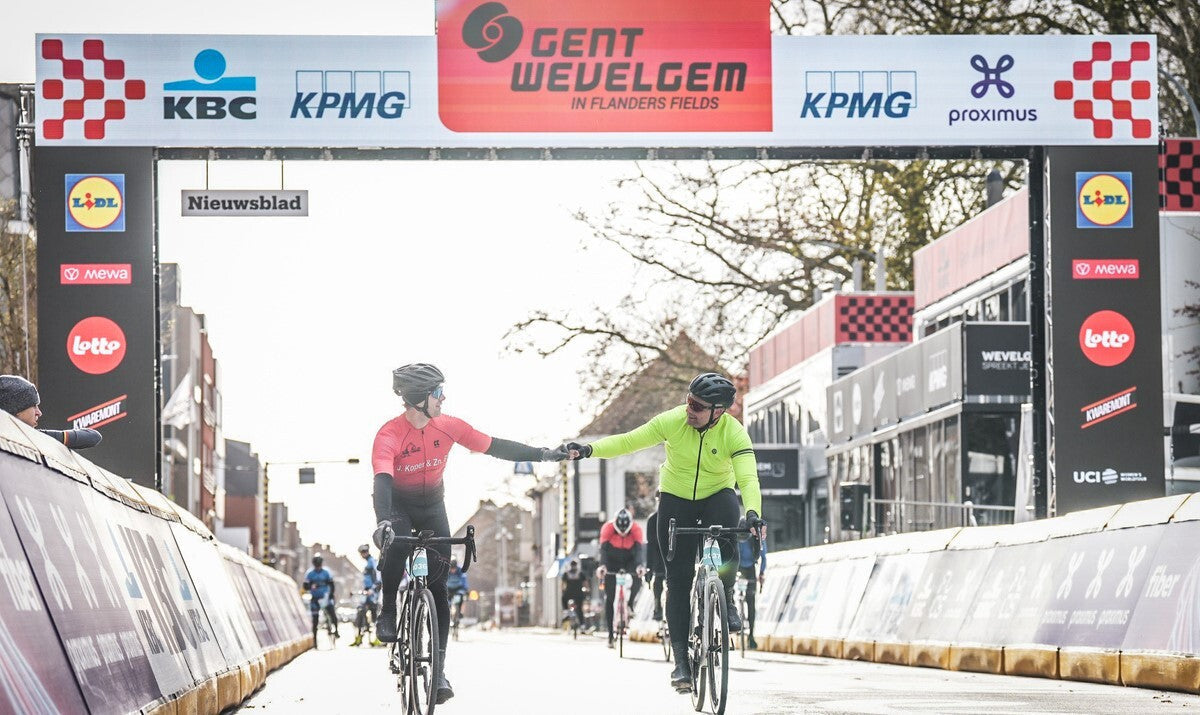 Two riders celebrating with a fist bump at the finish of Gent Wevelgem Cyclo